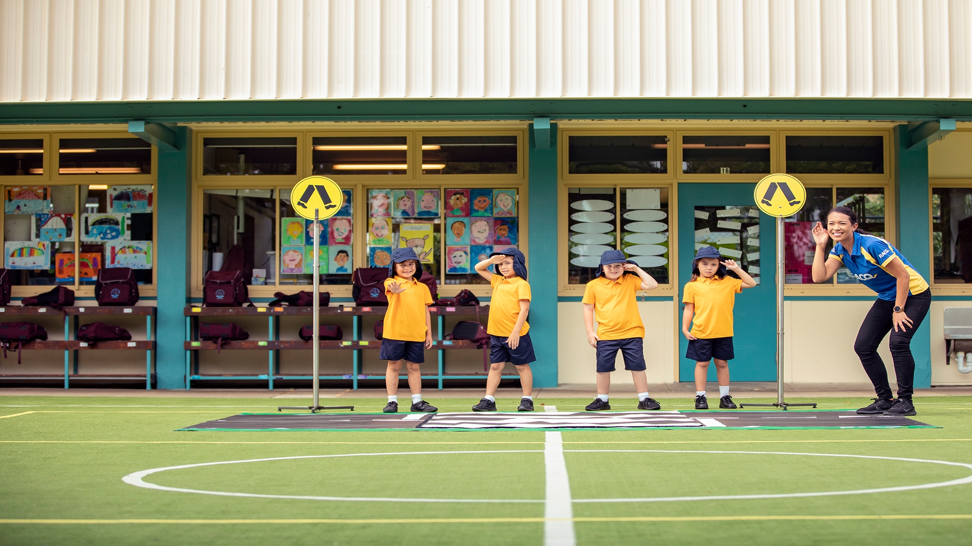 Primary school students practicing a road safety activity on a school playground.