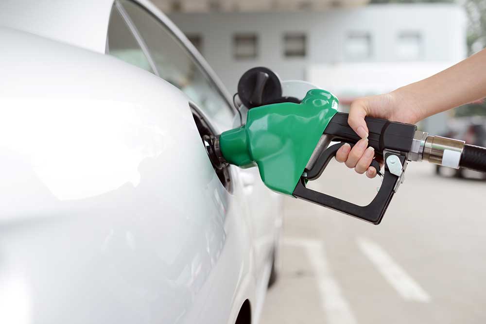 hand pumping fuel into car