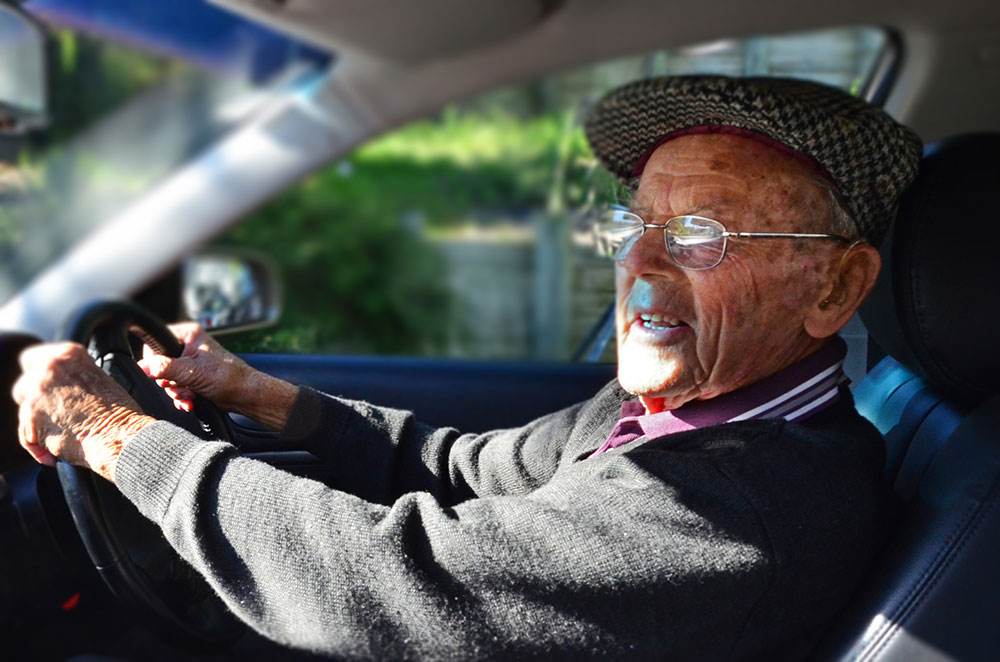 Elderly man driving car.