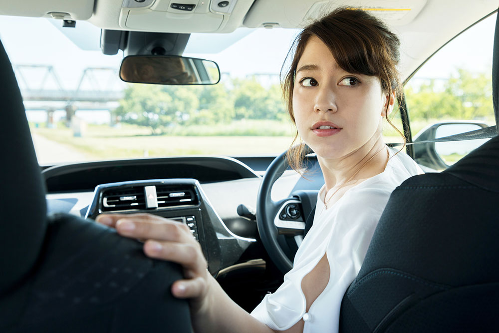 Woman reversing into carpark.
