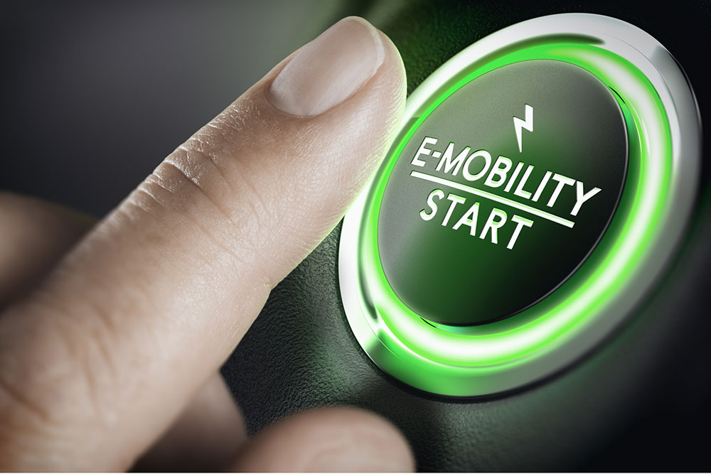 Finger about to push the start button of an EV.