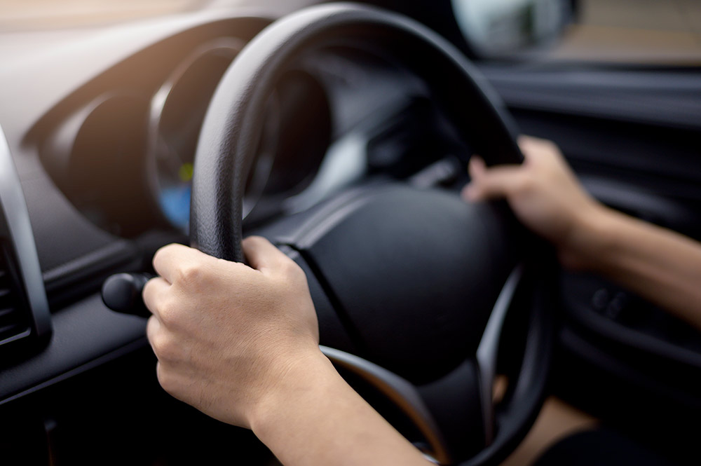 Driver with hands on steering wheel