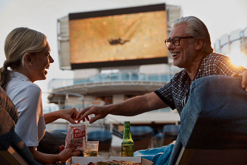 Older couple watching an outdoor movie on Princess Cruises ship.