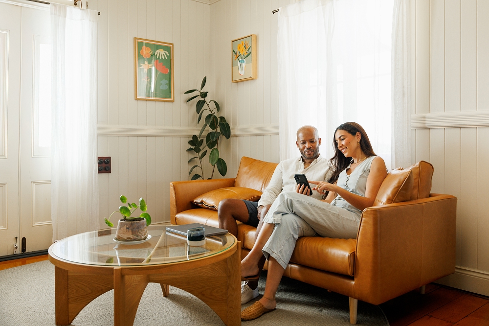 Couple reviewing home improvement ideas on a smartphone in a living room