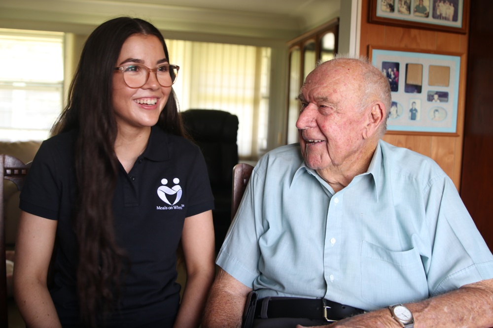 Meals on Wheels employee and elderly client.