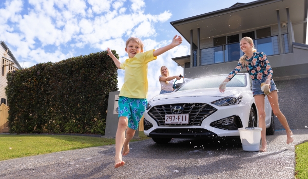 Family washing car in driveway