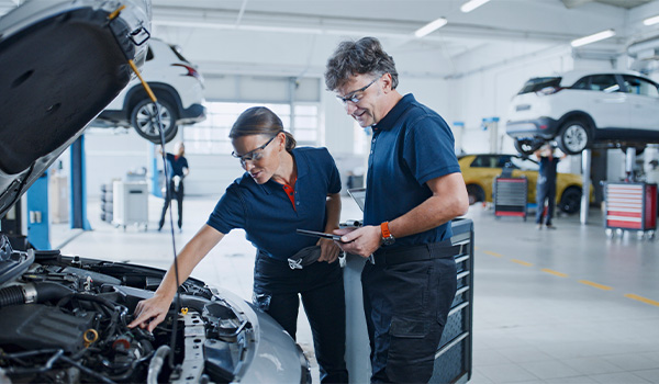 Mechanics looking at car