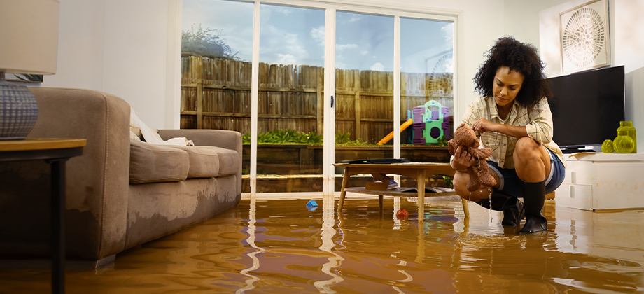 home indoors damaged by wet weather and woman cleaning up