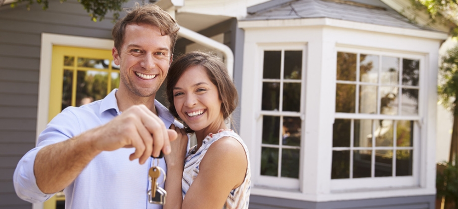 Young couple in front of new house
